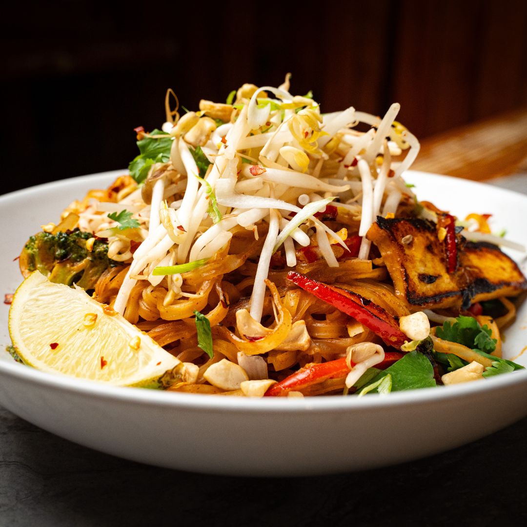 Vegan Pad Thai with an Almond Tamarind Sauce, Tofu, Broccoli, Red Peppers, Sprouts, Cashews, Green Onion, and Lime